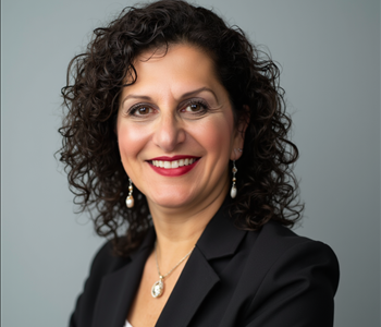 Woman with shoulder length curly hair and a black blazer