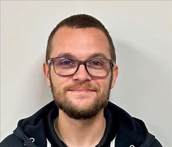 Young man with dark hair and glasses