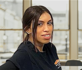 smiling brunette woman with a black Servpro vest on