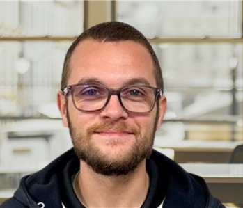 Young man with dark hair and glasses