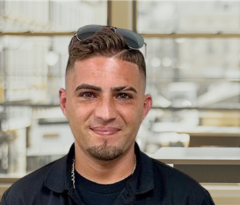 Young man with dark hair and a servpro shirt and sunglasses on his head