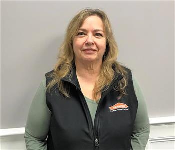 woman with long blonde hair and black servpro fleece vest