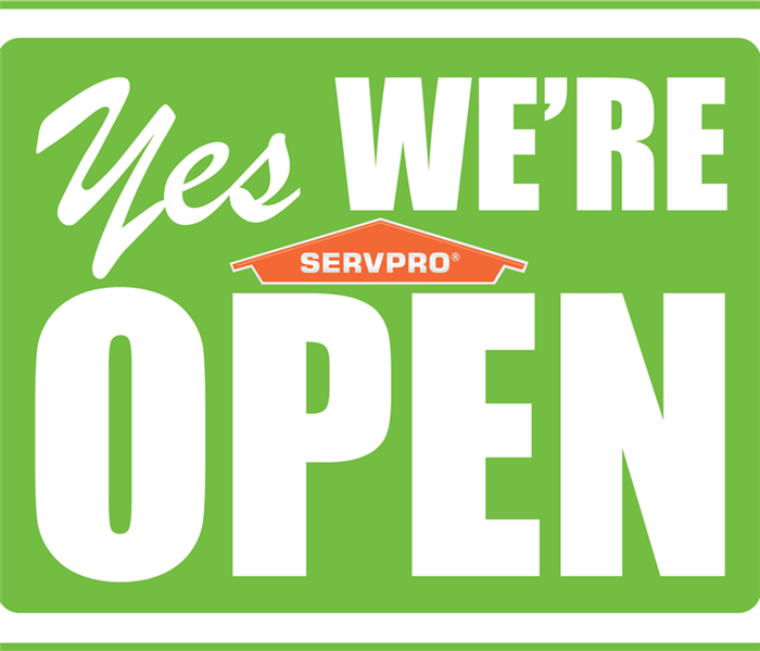 a sign that says yes we're open with a SERVPRO symbol