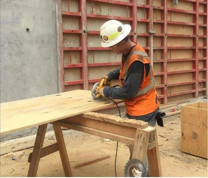 Contractor cutting wood in a commercial warehouse