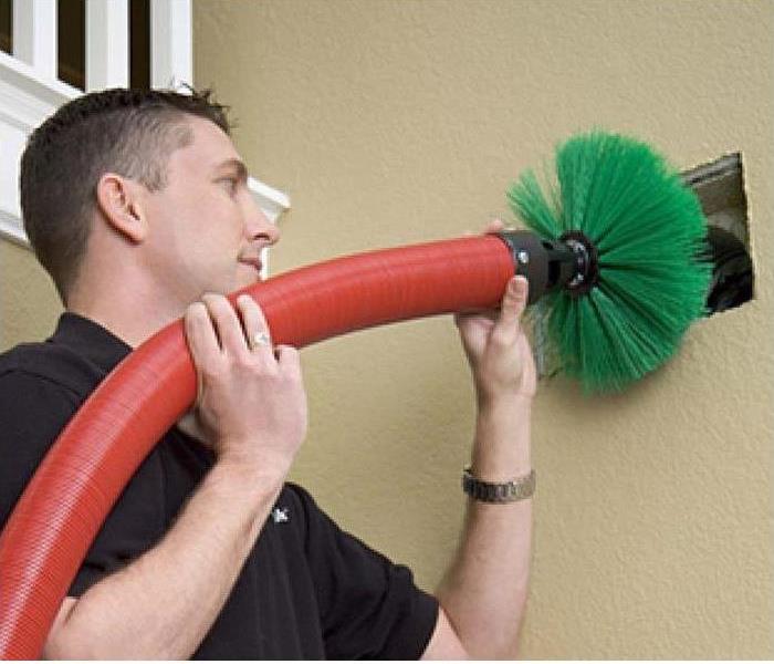 servpro employee cleaning a duct