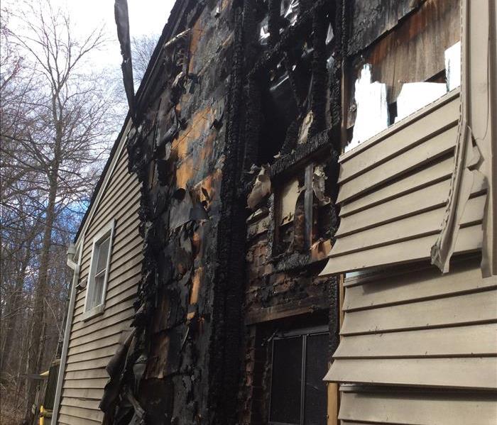 exterior of a house with vinyl siding and wood structure burned