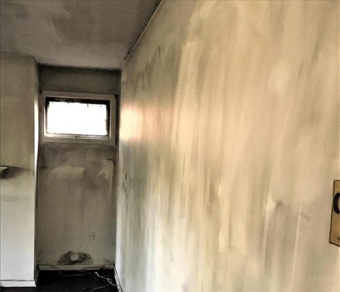 wall of an apartment building hallway covered in soot
